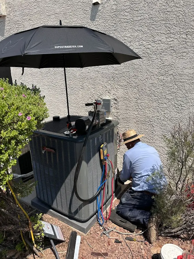 HVAC technician performing outdoor AC maintenance in Rumford